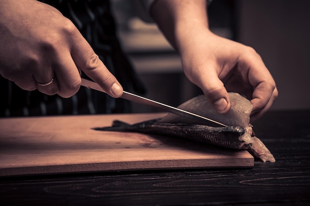 Chef cortando el pescado en una tabla