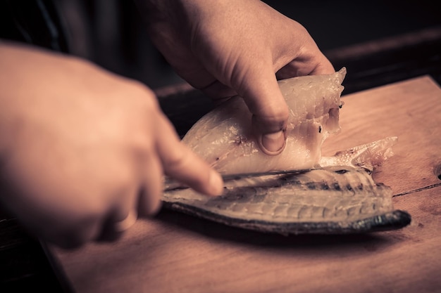 Chef cortando el pescado en una tabla