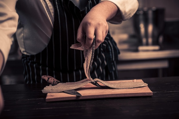 Chef cortando el pescado en una tabla