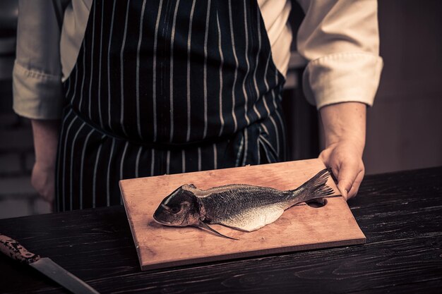 Chef cortando el pescado en una tabla