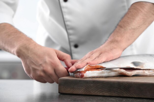 Foto chef cortando salmón fresco en la cocina