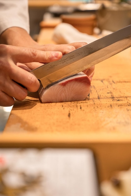 Foto el chef está cortando sashimi.