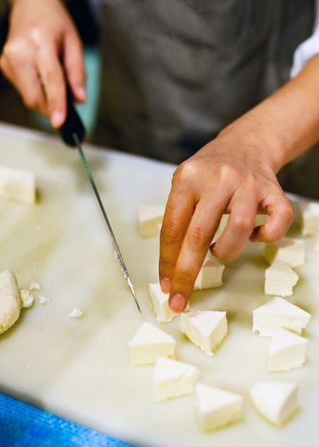 Chef cortando tofu para cocinar, Chef cocinando comida en la cocina, tofu fresco