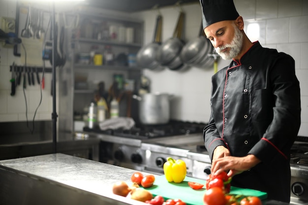 Chef cortando uma pimenta vermelha