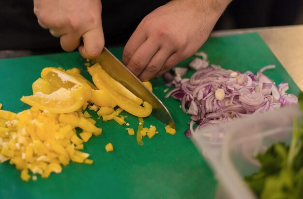 Chef cortando vegetais frescos e deliciosos para cozinhar ou salada