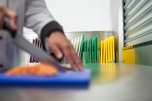 Foto chef cortar salmón crudo con cuchillo