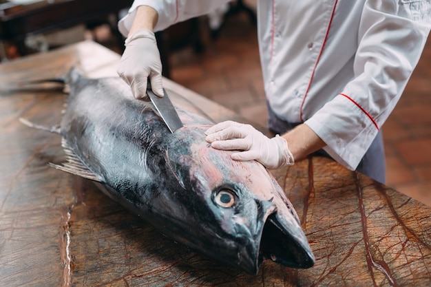 El chef cortó un gran atún en el restaurante.