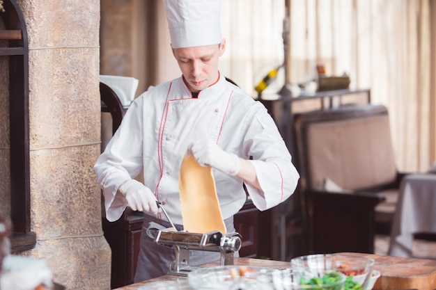 Chef cozinha espaguete em um restaurante premium.