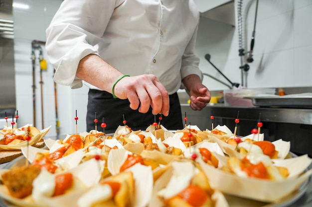 Chef cozinhando deliciosas batatas brava Comida típica espanhola com elegante barquinho de papel Tapas