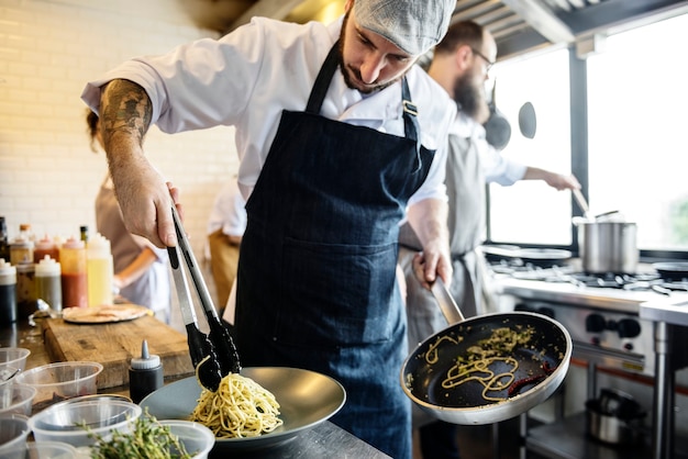 Chef cozinhando spagetti na cozinha