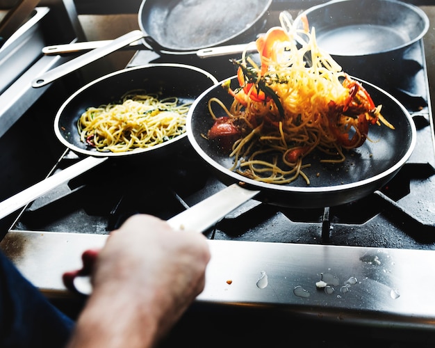 Chef cozinhando spagetti na cozinha