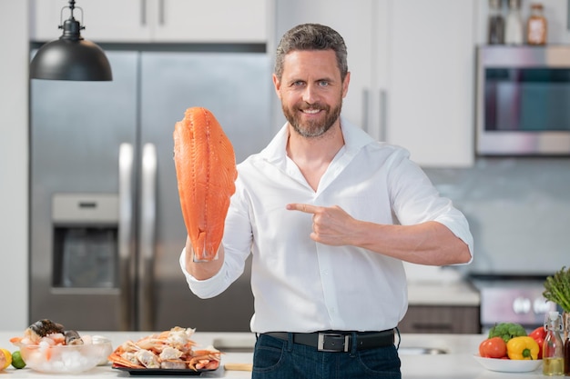 Chef cozinheiro em camisa cozinhando filé de salmão de peixe cru no conceito de menu de restaurante de cozinha chef masculino h
