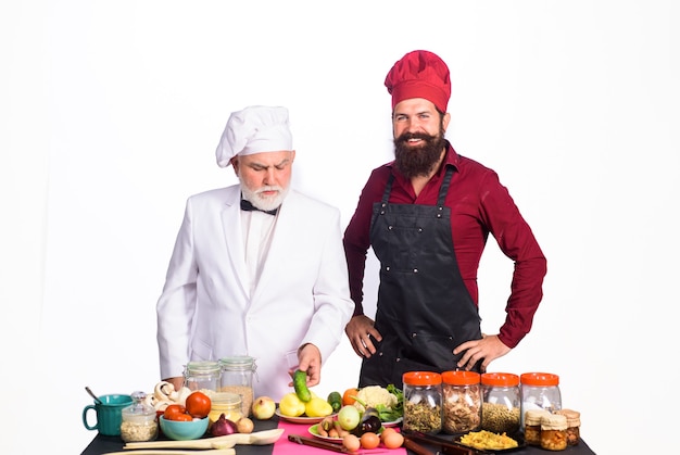 Chef culinarios profesionales hombres barbudos en uniforme listo para cocinar chef de comida saludable con asistente en