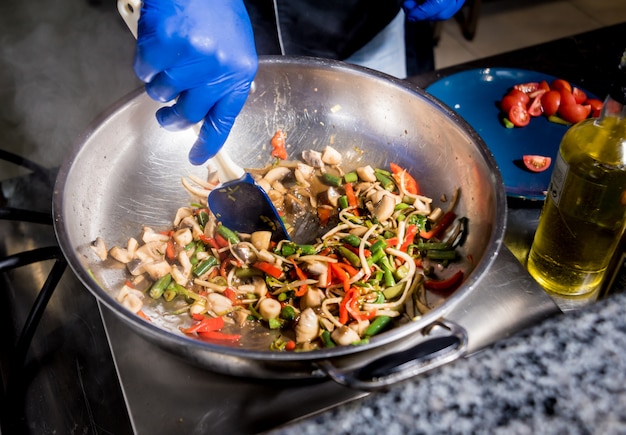 Chef de cozinha macarrão com legumes na panela. Cozinha de estilo italiano. Restaurante.