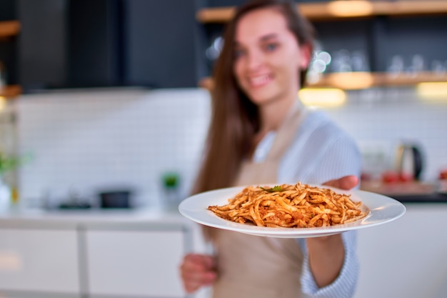 Foto chef de cozinha segurando um prato de macarrão