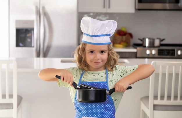 Chef de criança engraçado cozinhar culinária na cozinha Garoto de chef fazendo comida saudável Retrato de criança com chapéu de chef