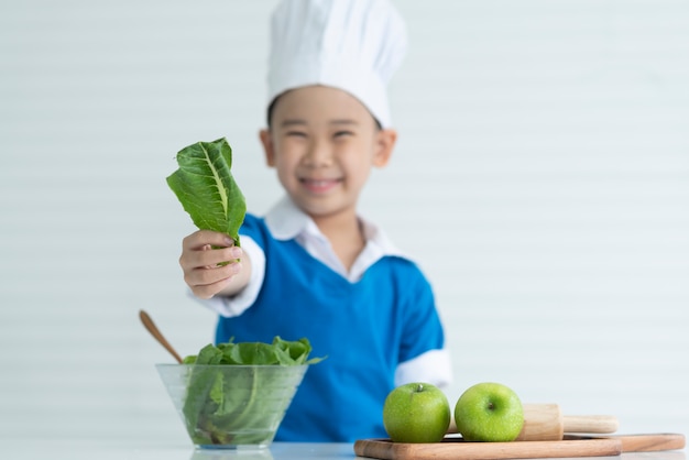 Chef de criança está feliz com legumes frescos