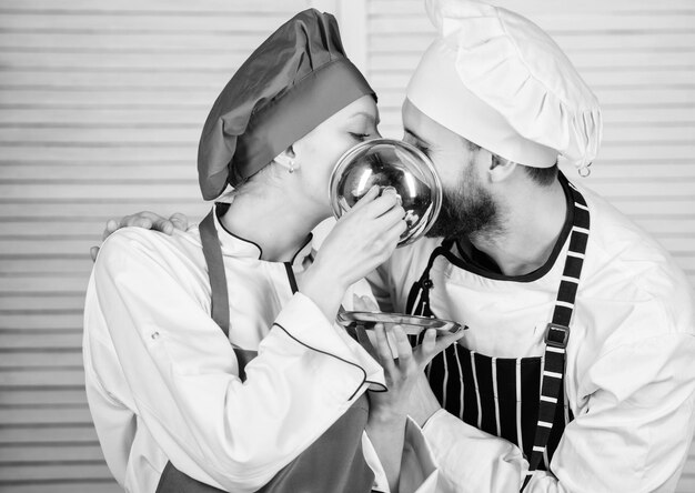 Chef de homem e mulher no restaurante atrás do ingrediente secreto da bandeja metálica pelo uniforme do cozinheiro da receita Família cozinhando na cozinha casal apaixonado por comida perfeita Planejamento de menu cozinha culinária