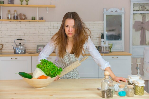 Chef de mulher na cozinha com rolo nas mãos.