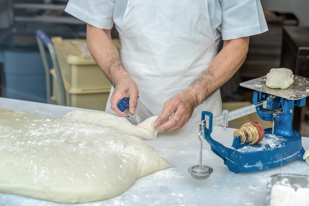 Chef de pão Mão, corte a farinha de pão e equilíbrio na máquina de escalas