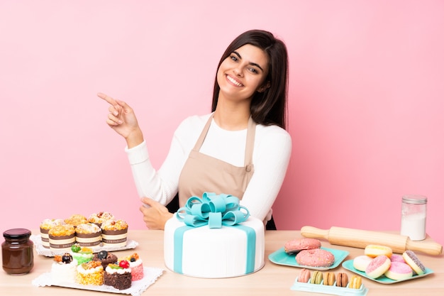 Foto chef de pastelaria com um bolo grande em uma tabela