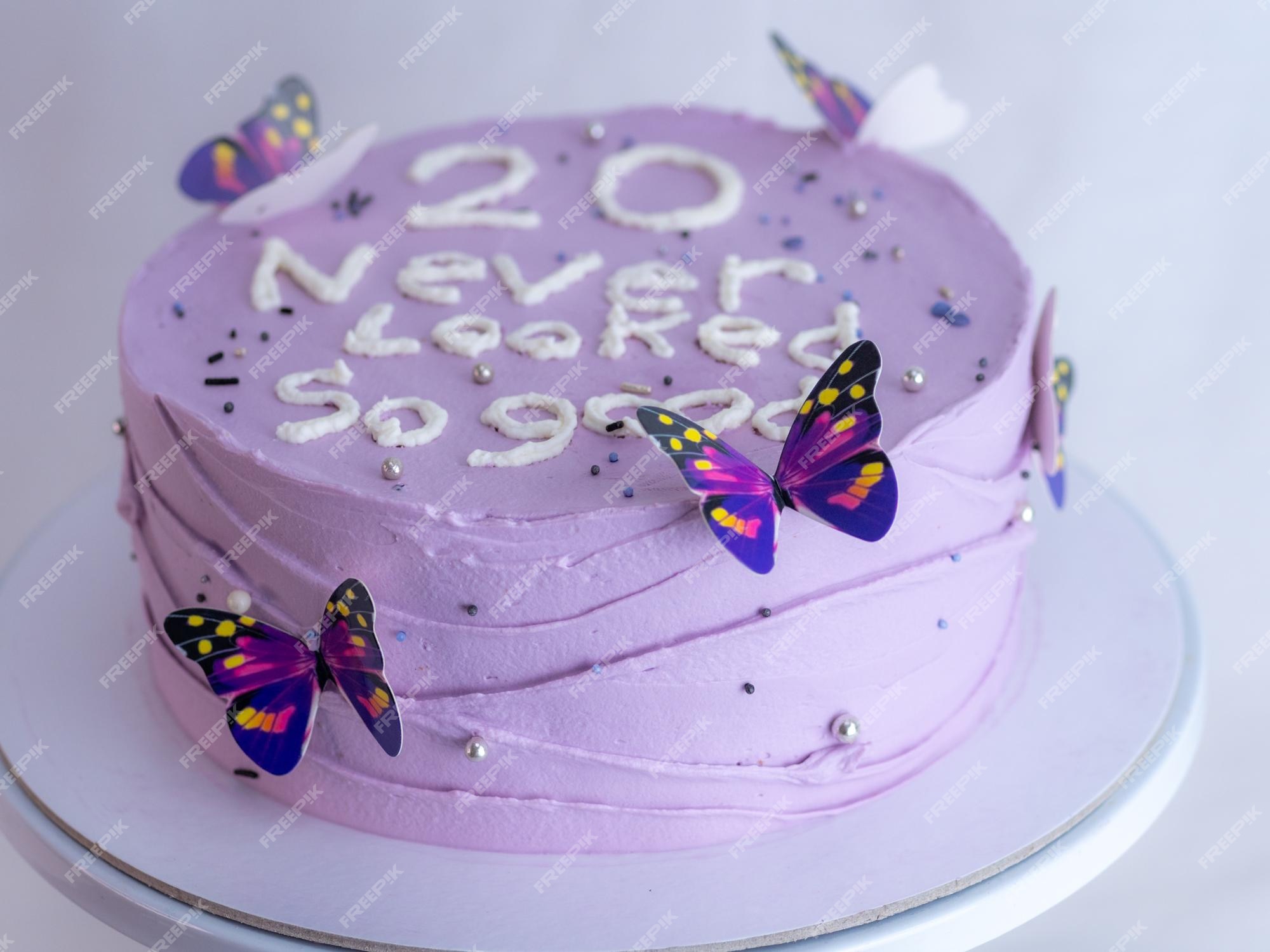 Chef de pastelaria decorando um bolo de aniversário fosco roxo com  cobertura de texto polvilha pérolas e borboletas