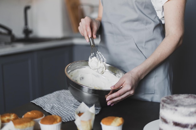 Foto chef de pastelaria jovem adorável preparando creme de bolo em casa