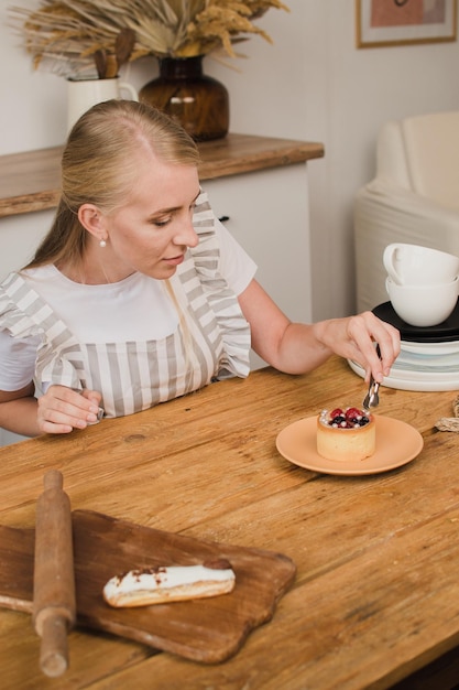 Chef de pastelaria mulher no avental decora a sobremesa