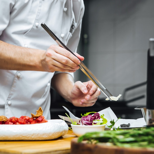 Foto chef de restaurante cozinha carpaccio de filé mignon com parmesão e rúcula