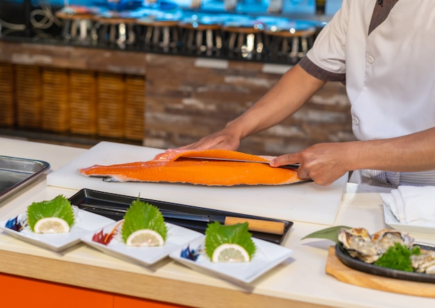 Chef de salmão de corte para sashimi, comida japonesa