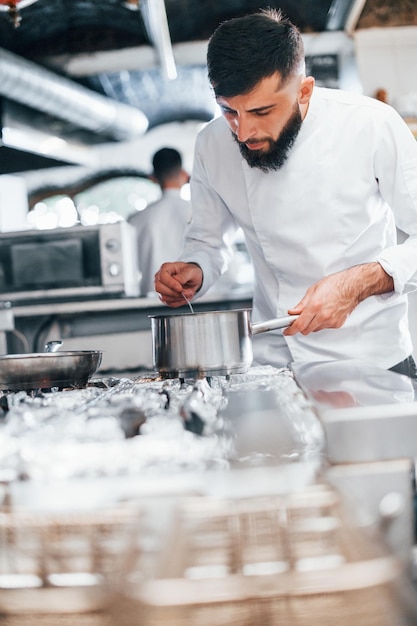 Chef de uniforme branco cozinhando comida na cozinha Dia ocupado no trabalho