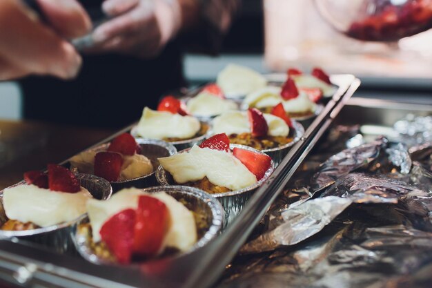 Foto un chef decora muchos platos de pastel