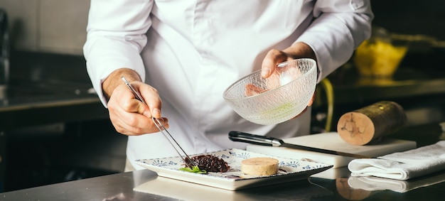 Foto el chef decora un plato de foie gras