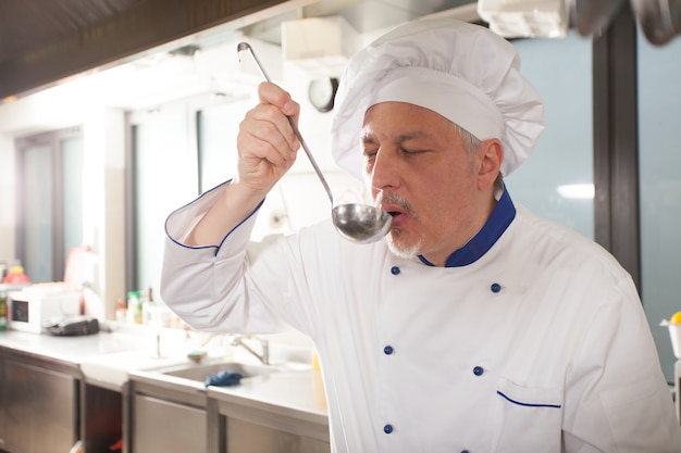 Chef degustando comida en su cocina