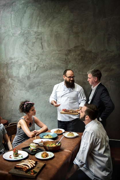 Chef, der den Kunden im Restaurant Lebensmittel präsentiert