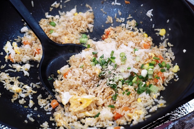 Foto chef, der gebratenen reis in einer bratpfanne kocht