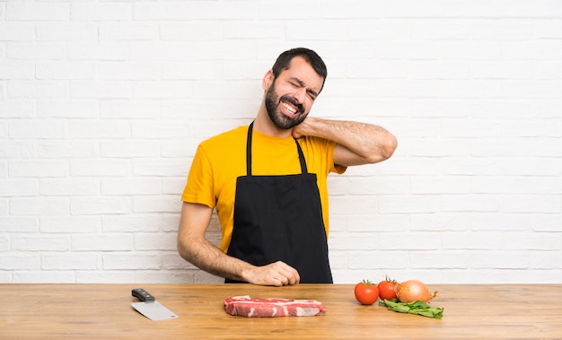 Chef, der in einer Küche mit Halsschmerzen hält