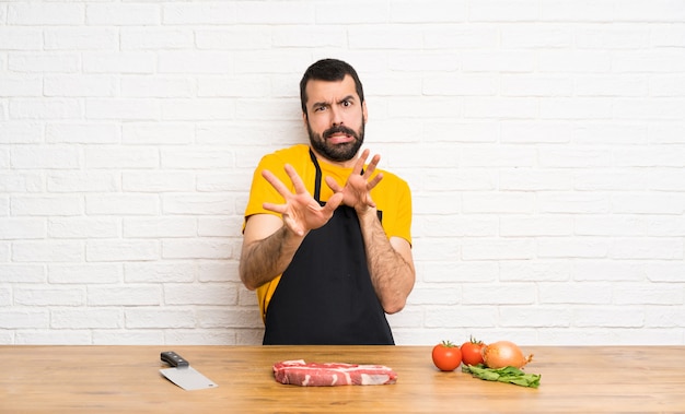 Chef, der in nervösen ausdehnenden Händen einer Küche zur Front hält