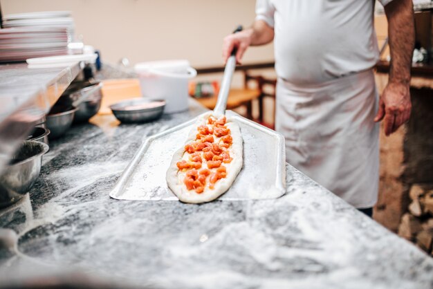 Chef, der mazedonische Pizza zubereitet.