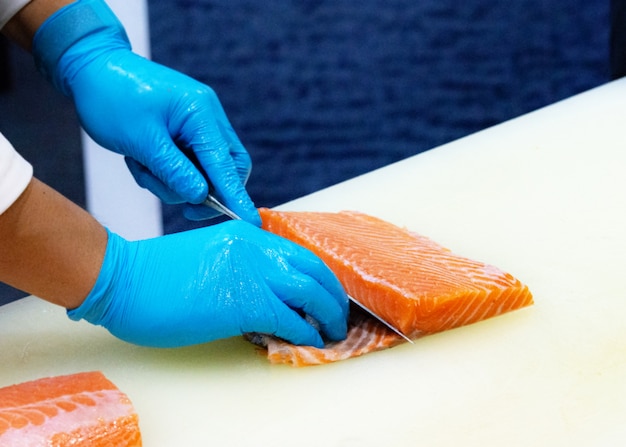 Chef, der rohen frischen Lachs, Chef einen frischen Lachs auf einem Schneidebrett vorbereiten schneidet