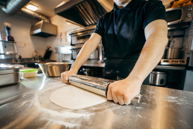 Chef, der Teig in einer Küche vorbereitet