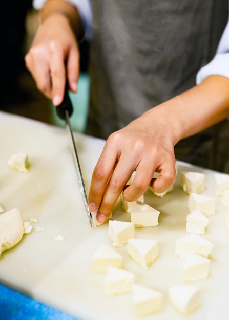 Chef, der Tofu für das Kochen schneidet, Chef, der Lebensmittel in der Küche kocht, frischer Tofu