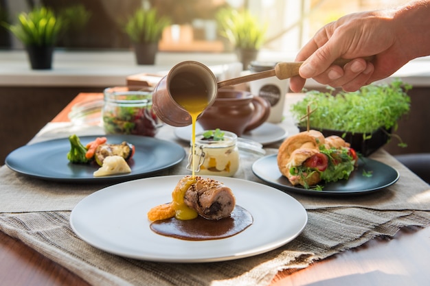 Chef, derramando com rolo de carne sause.