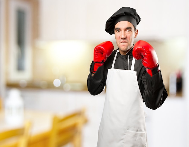 Foto chef enojado con guantes de boxeo