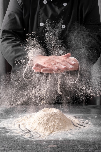 Chef, esfregando as mãos com farinha