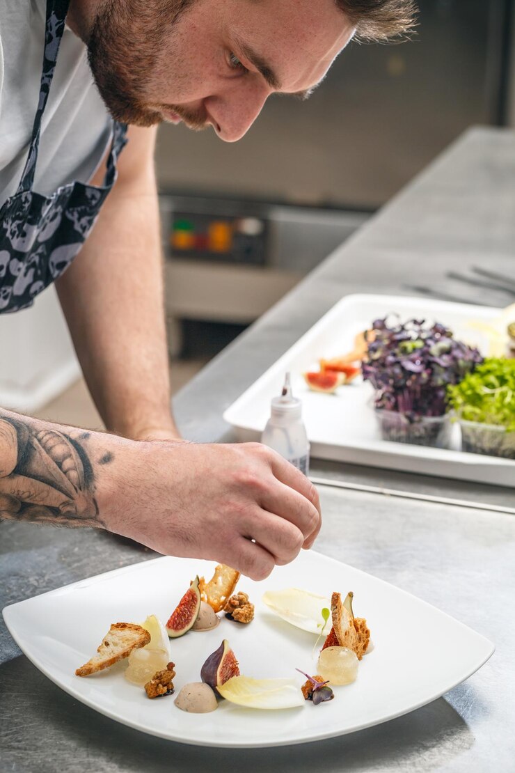 El chef está adornando un plato de aperitivo.
