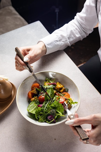 Un chef está comiendo una ensalada en un bol.