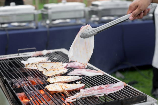 Chef está cozinhando lulas grelhadas com especiarias asiáticas