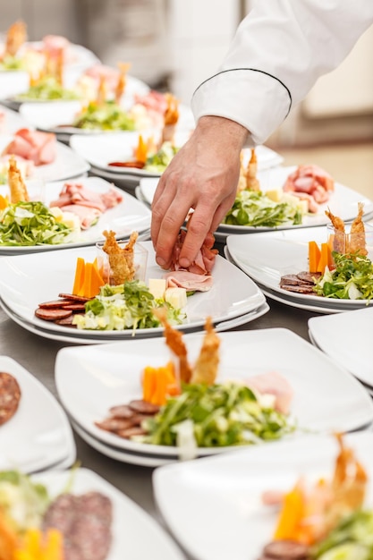 Chef está decorando deliciosos pratos de aperitivo