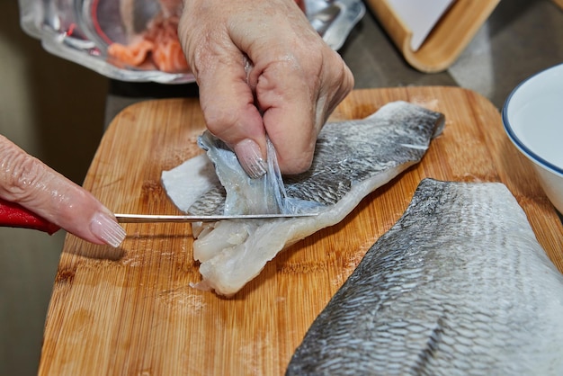 Chef está descascando filés de salmão para cozinhar